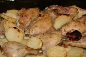 Mix garlic sauce with baked chicken and potatoes then broil for a few more minutes